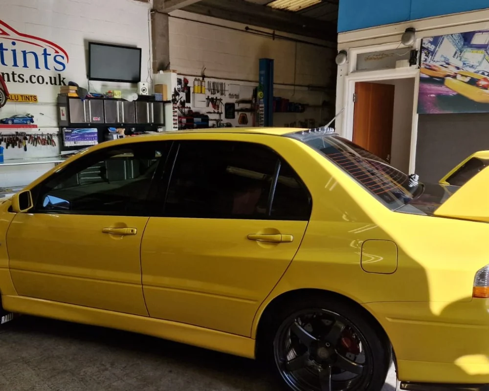 Yellow Mitsubishi Evo with tinted windows inside Valu Tints