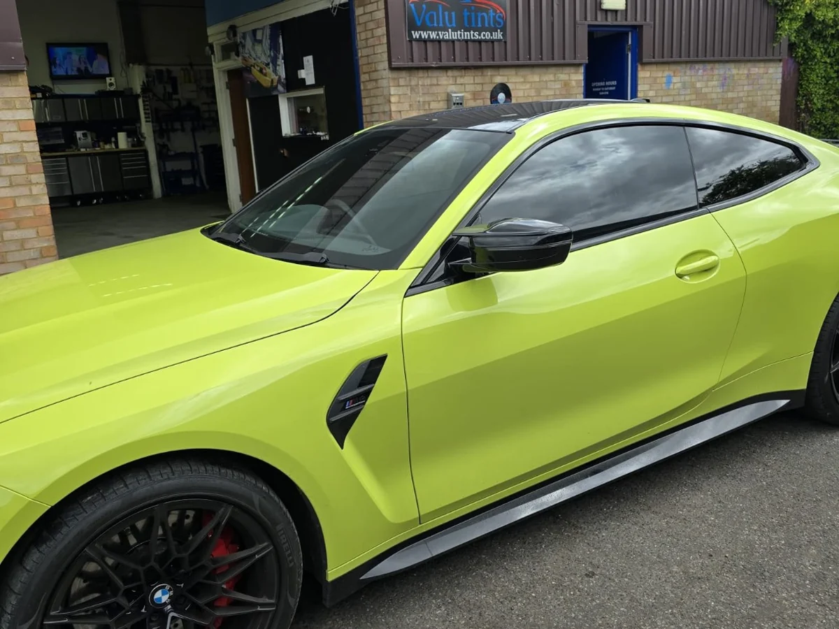 Lime green BMW with completed window tinting outside Valu Tints